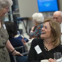 Woman stopping by table to say hello to Donna Brooks